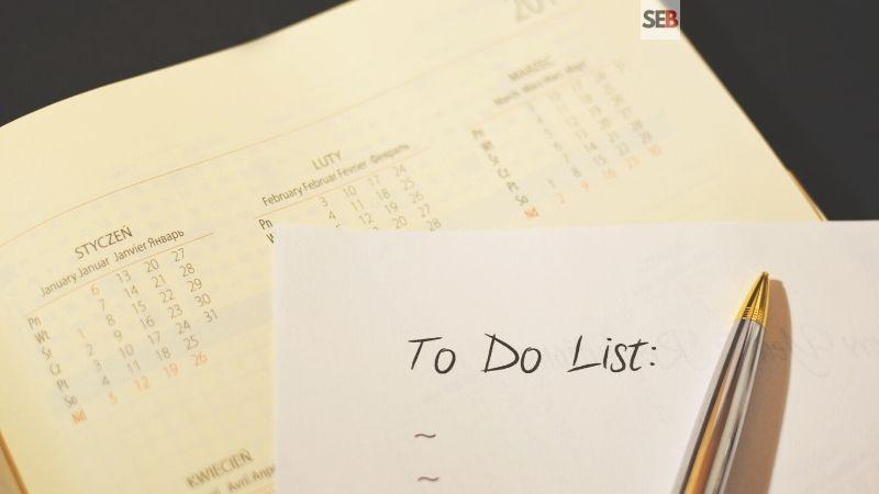 Event planning checklist - pen and paper written to do list on top a calandar