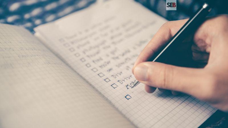 Event planning checklist -hand holding pen writing out to-do list