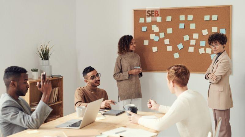 To hire professional event planner or not to - brown board with sticky notes plus two women standing near by