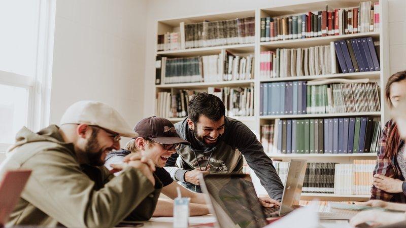 how to make your employees happy - smiling colleagues working on a project